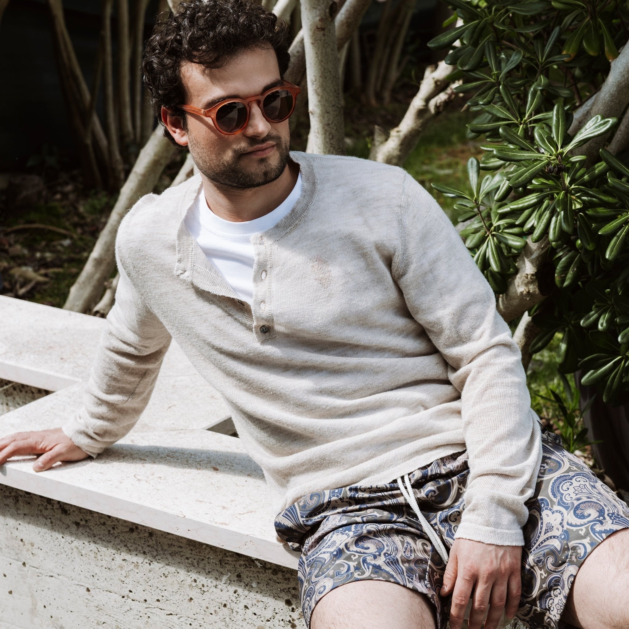 Modello con indosso il costume da bagno in fantasia verde abbinato al un serafino beige-Valensia